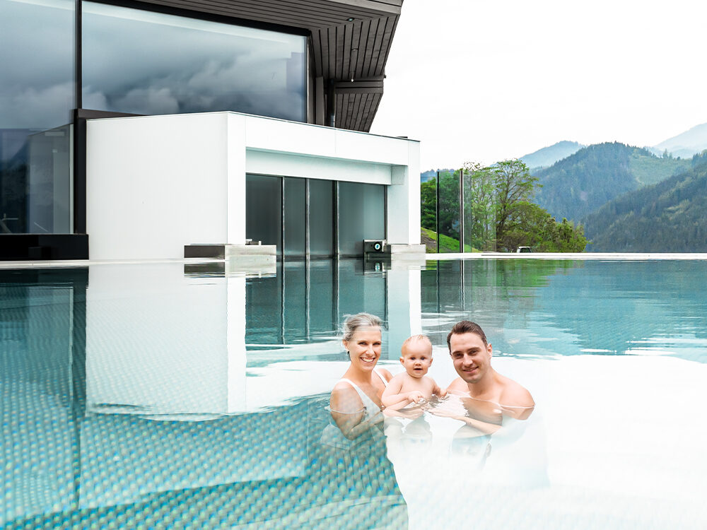 Familie im Pool vor Schiebetüre